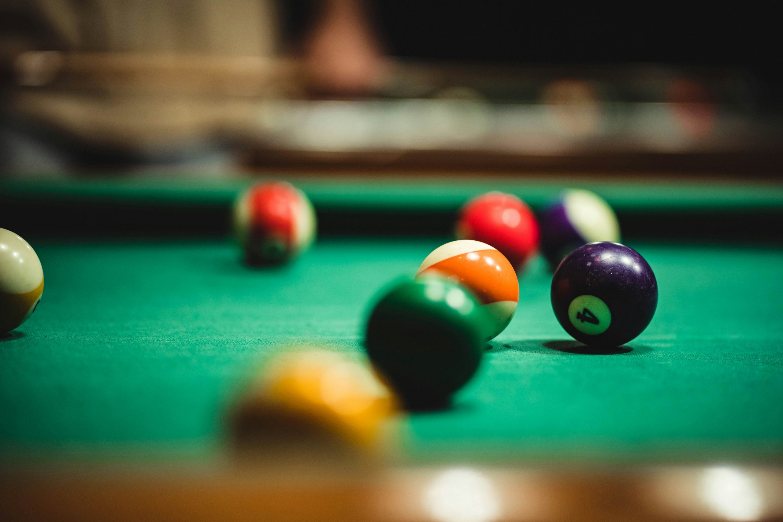 Pool balls spread out on a table, soft focus background and foreground.