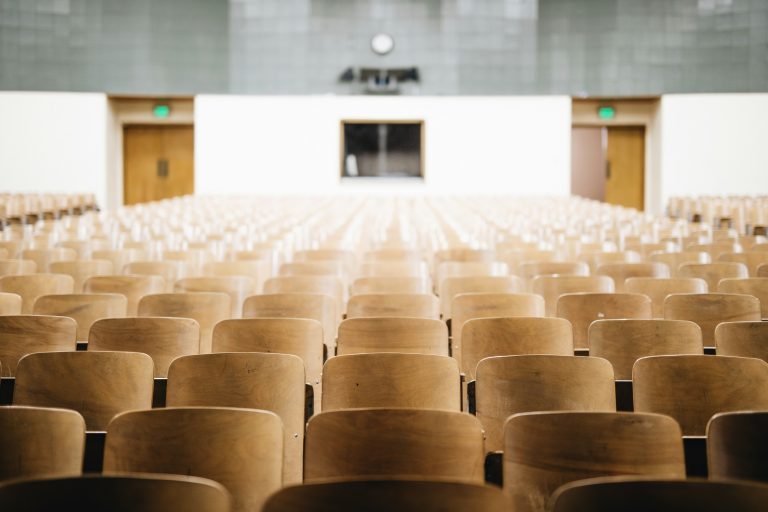 Rows of empty seats in a modern lecture hall.