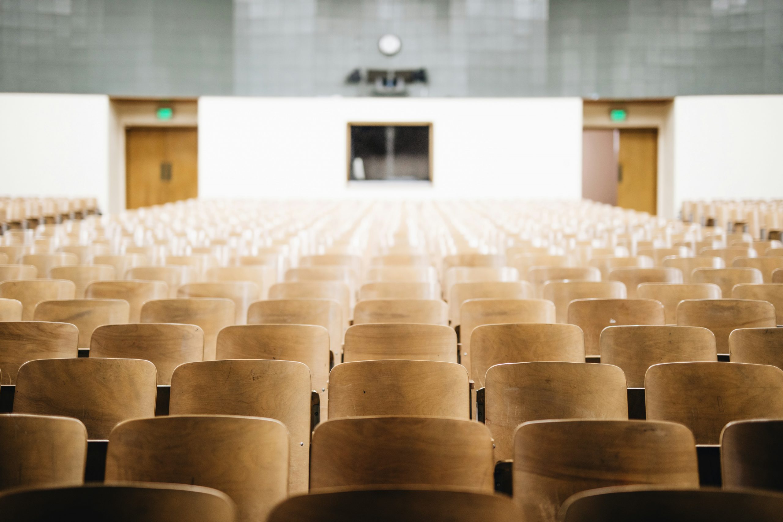 Rows of empty seats in a modern lecture hall.