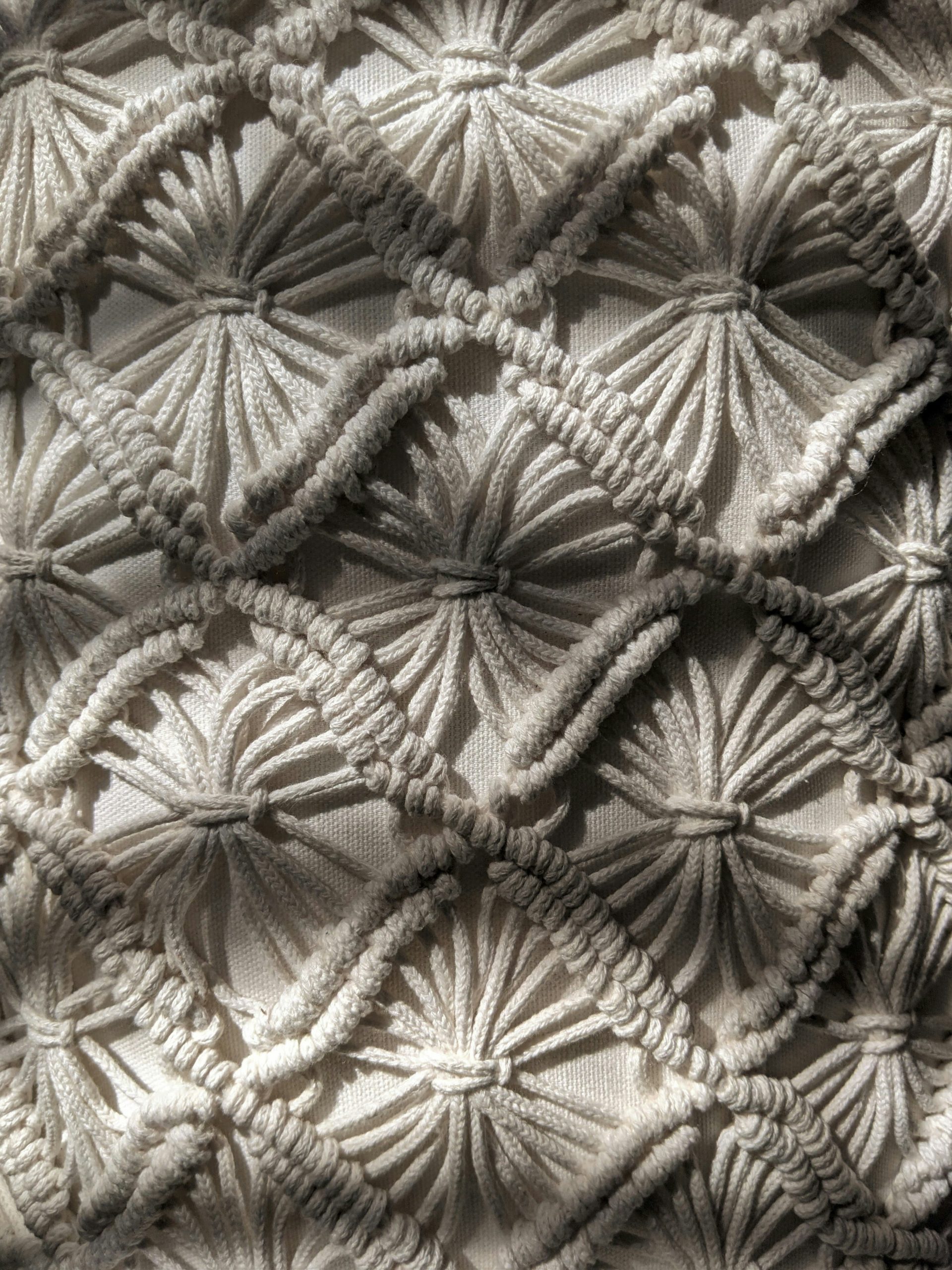 Weaves of white yarn in the style of macrame.